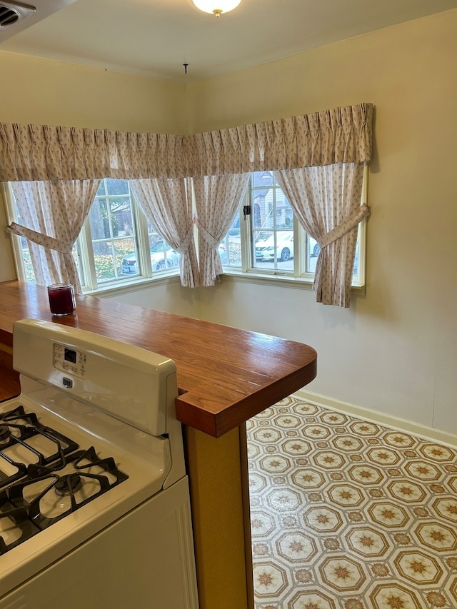 kitchen featuring wooden counters and white range with gas stovetop