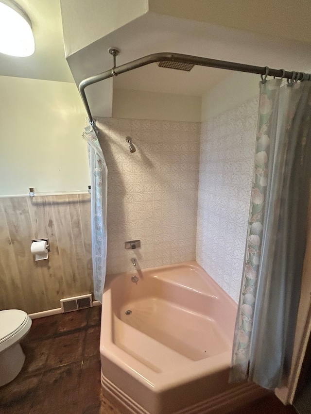 bathroom with toilet and shower / bath combo with shower curtain