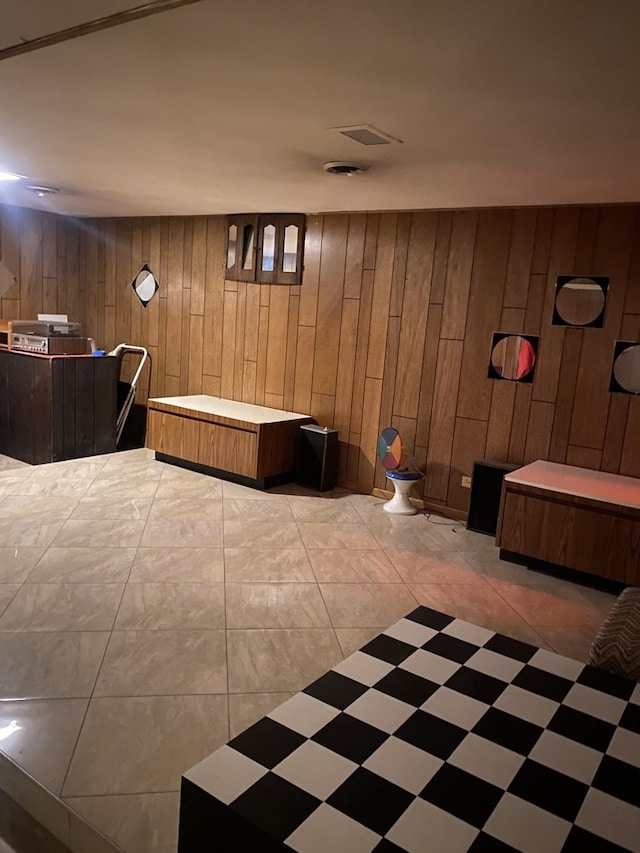 bathroom featuring tile patterned floors and wood walls