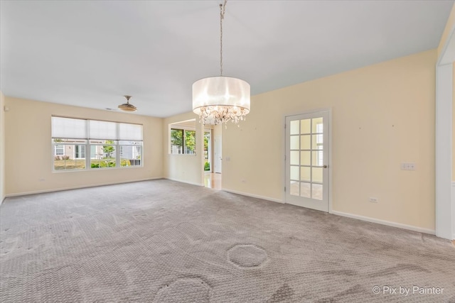 carpeted empty room with ceiling fan with notable chandelier