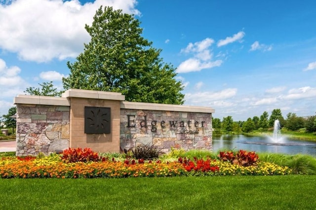 community sign with a yard and a water view