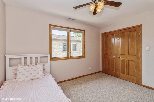 bedroom featuring light carpet, ceiling fan, and a closet