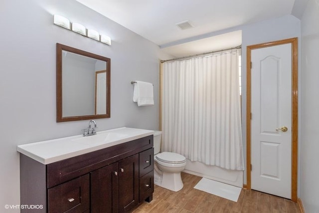 full bathroom featuring shower / bath combination with curtain, wood-type flooring, toilet, and vanity