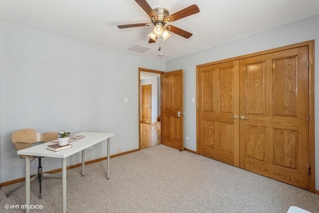 unfurnished office featuring ceiling fan and light carpet