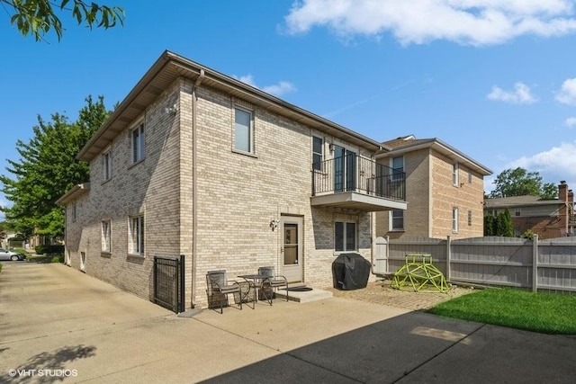 rear view of property with a patio area and a balcony