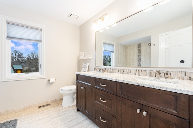 bathroom featuring tasteful backsplash, vanity, a shower, tile patterned flooring, and toilet