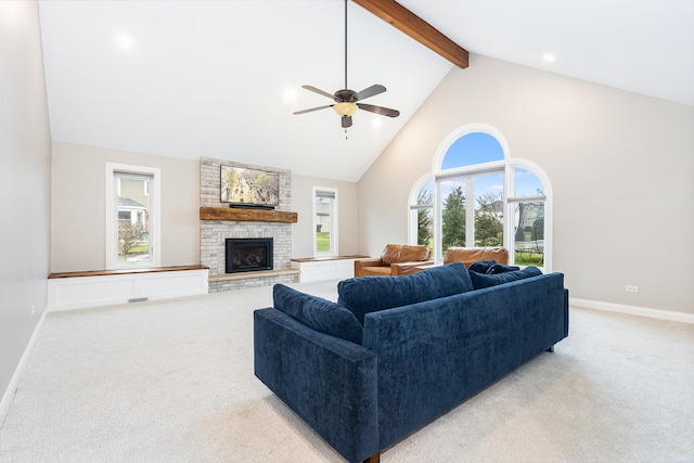 carpeted living room featuring ceiling fan, a fireplace, high vaulted ceiling, and beamed ceiling