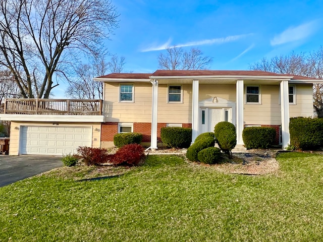 raised ranch with a front lawn and a garage