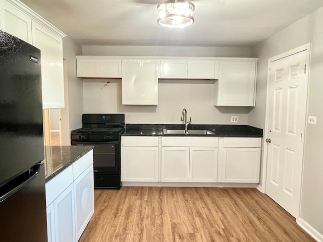 kitchen with black appliances, white cabinetry, sink, and light hardwood / wood-style flooring