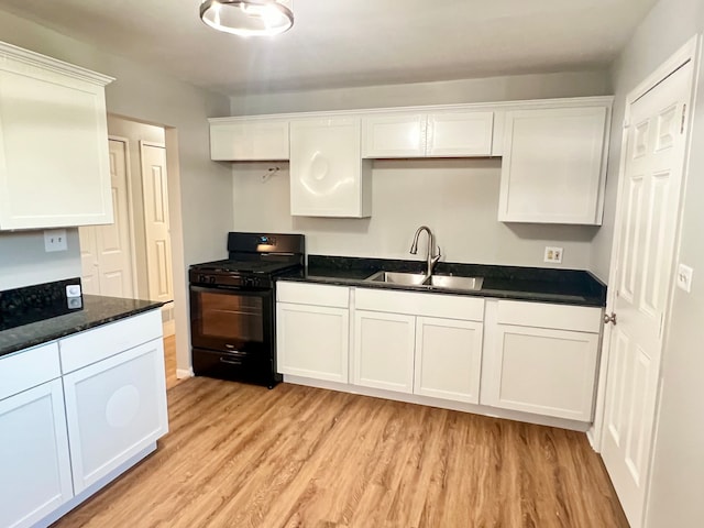 kitchen featuring sink, white cabinets, black gas range oven, and light hardwood / wood-style flooring