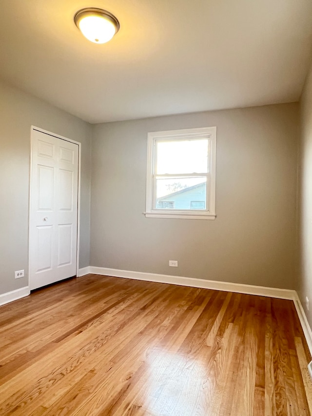 unfurnished bedroom with a closet and light hardwood / wood-style flooring