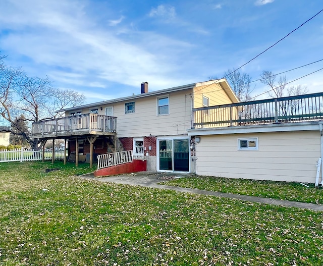 back of property with a patio, a wooden deck, and a lawn