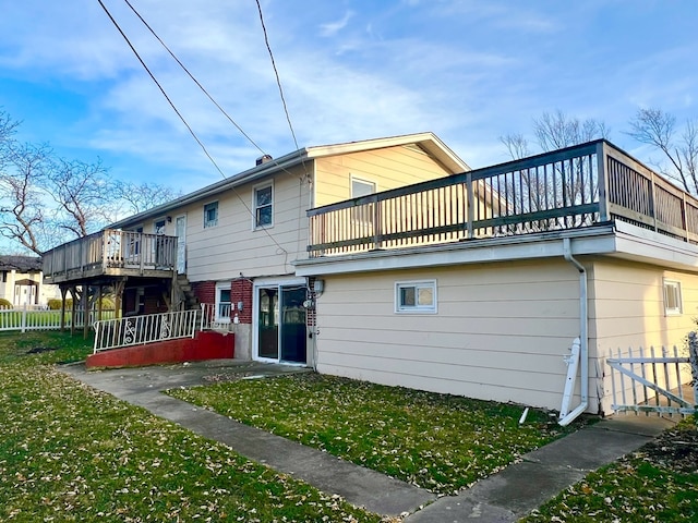 back of property with a balcony and a lawn