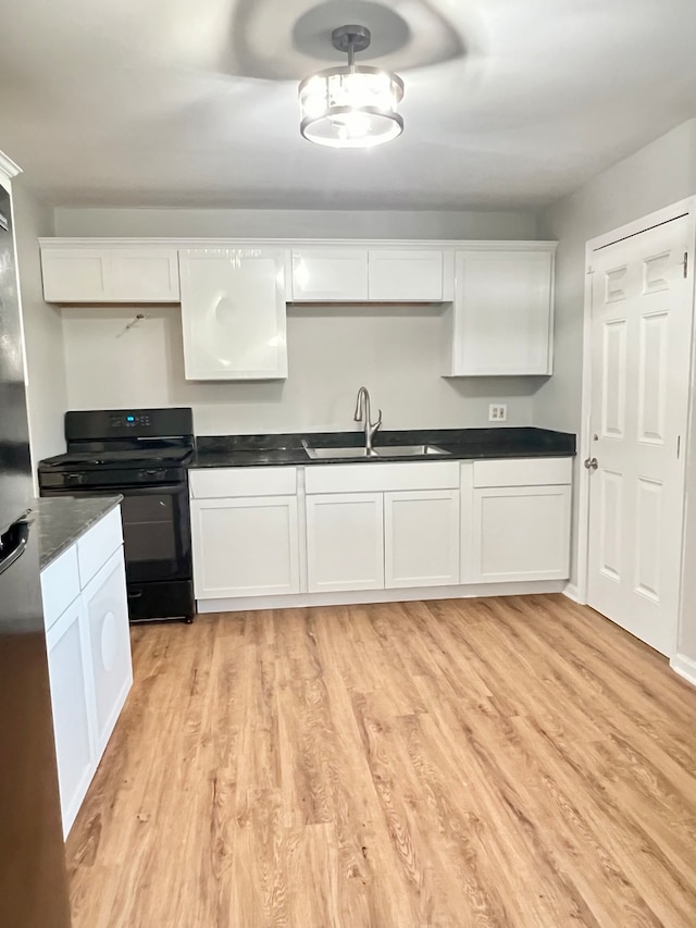 kitchen featuring white cabinetry, black range with gas stovetop, light wood-type flooring, and sink