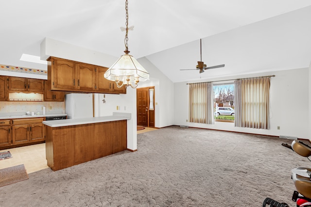 kitchen featuring pendant lighting, ceiling fan with notable chandelier, white refrigerator, and light carpet