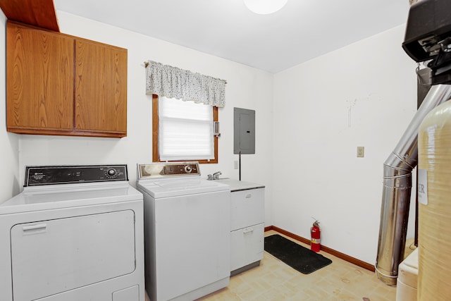 clothes washing area featuring washing machine and clothes dryer, electric panel, and cabinets