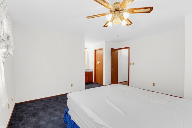 bedroom with connected bathroom, dark carpet, and ceiling fan