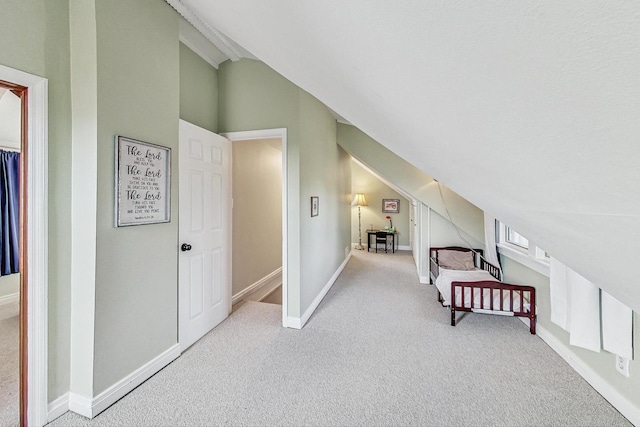 unfurnished bedroom featuring light colored carpet and vaulted ceiling