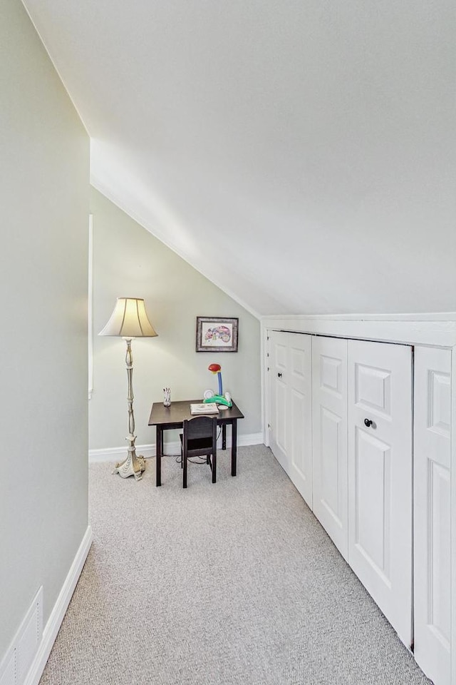 interior space with light colored carpet and vaulted ceiling