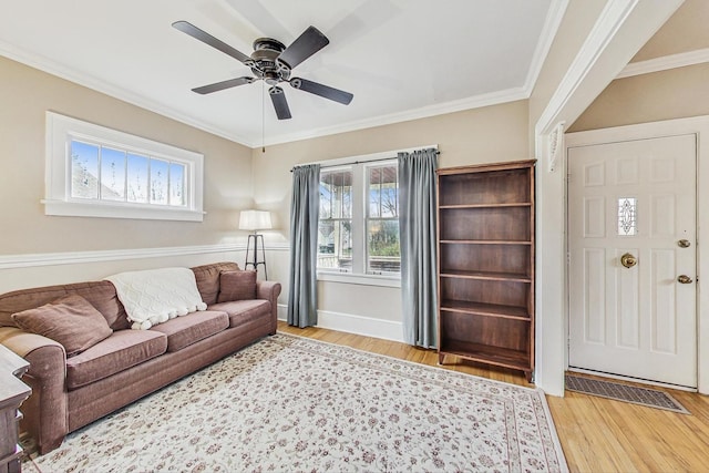 living room with light hardwood / wood-style floors, ceiling fan, and crown molding