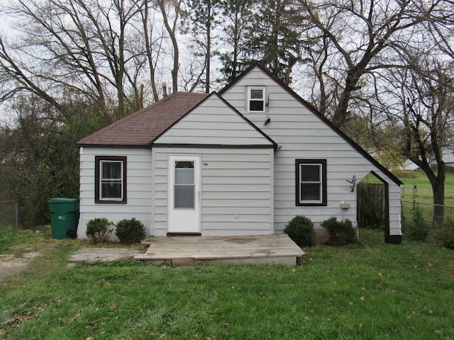 rear view of house with a deck and a yard