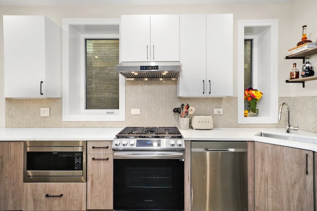 kitchen with sink, white cabinets, extractor fan, and appliances with stainless steel finishes