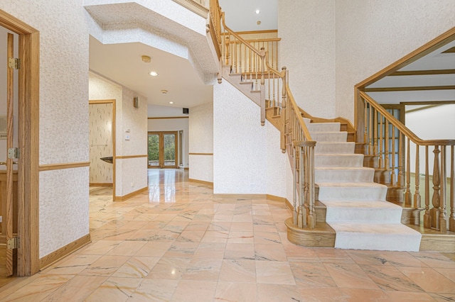 stairway featuring a high ceiling and french doors