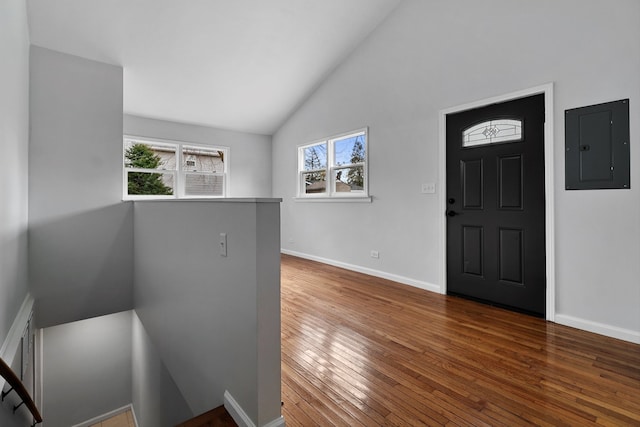 foyer entrance with electric panel, high vaulted ceiling, and dark wood-type flooring