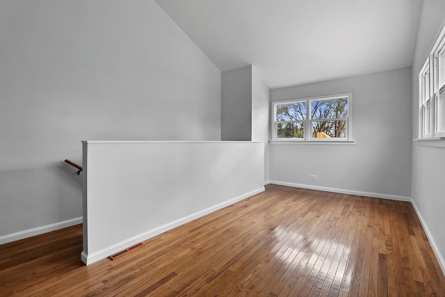 unfurnished room with dark hardwood / wood-style floors and lofted ceiling