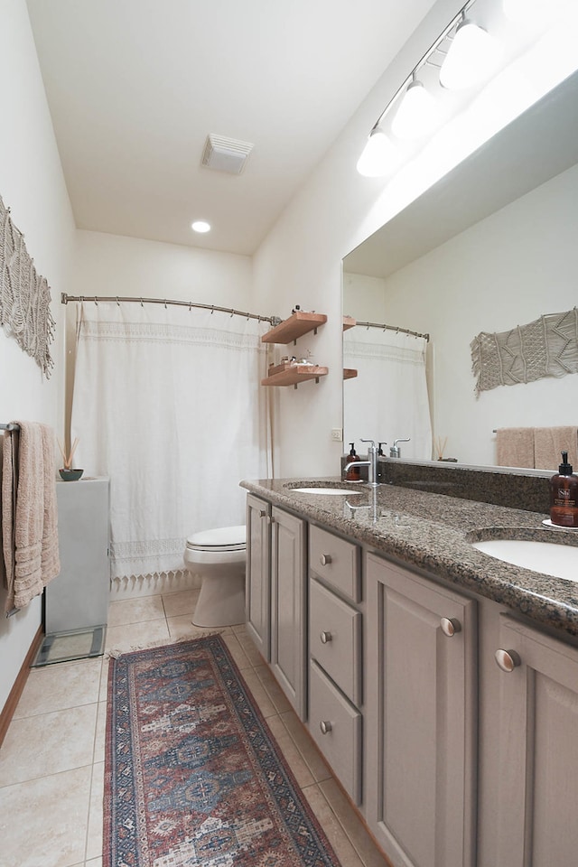 bathroom with tile patterned flooring, vanity, toilet, and curtained shower