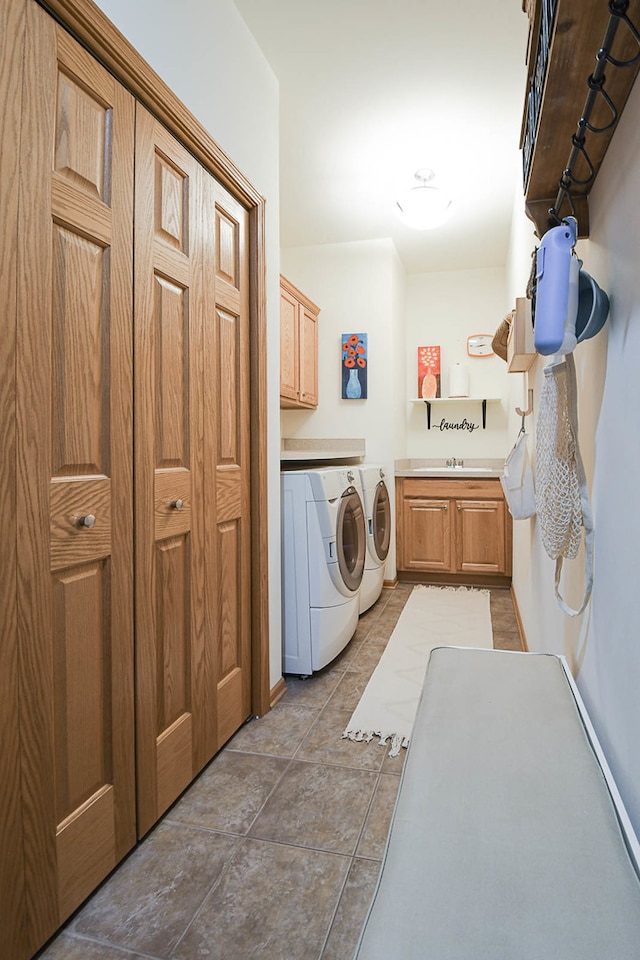 laundry room with washer and clothes dryer, cabinets, and tile patterned floors