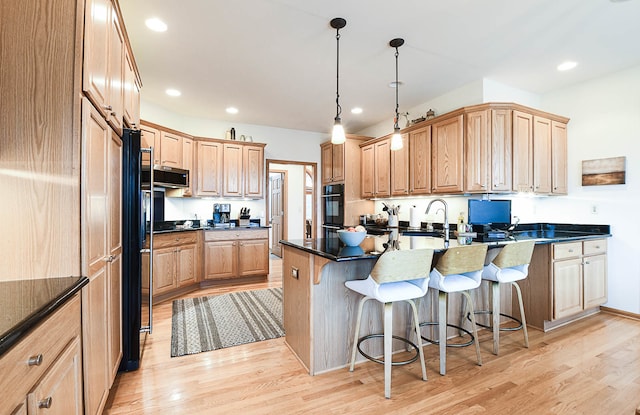 kitchen with a kitchen breakfast bar, kitchen peninsula, hanging light fixtures, and light wood-type flooring