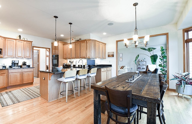 dining area featuring light hardwood / wood-style floors, a notable chandelier, and sink