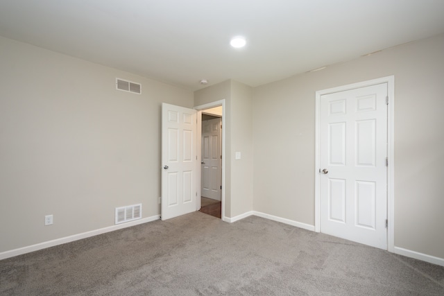 unfurnished bedroom with light colored carpet and a closet