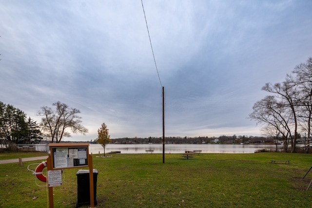 view of community featuring a lawn and a water view