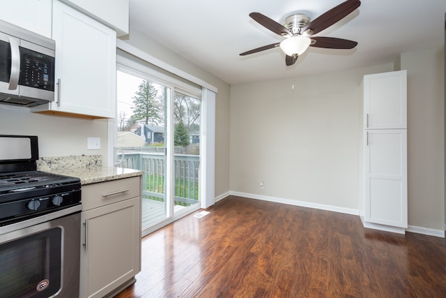 kitchen featuring light stone counters, dark hardwood / wood-style flooring, white cabinets, and stainless steel appliances