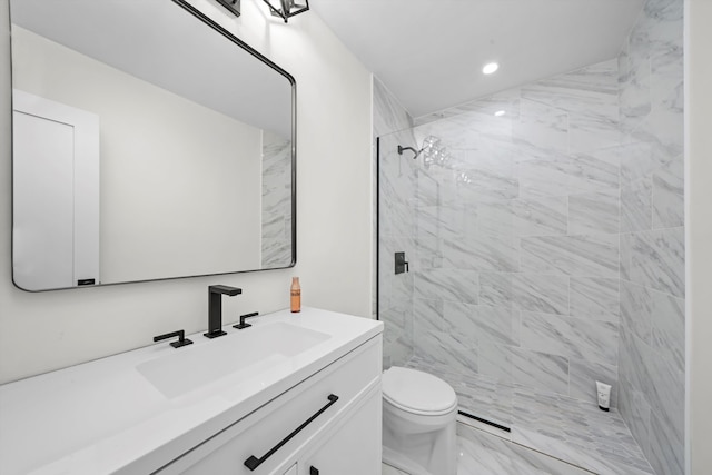 bathroom featuring tiled shower, vanity, and toilet