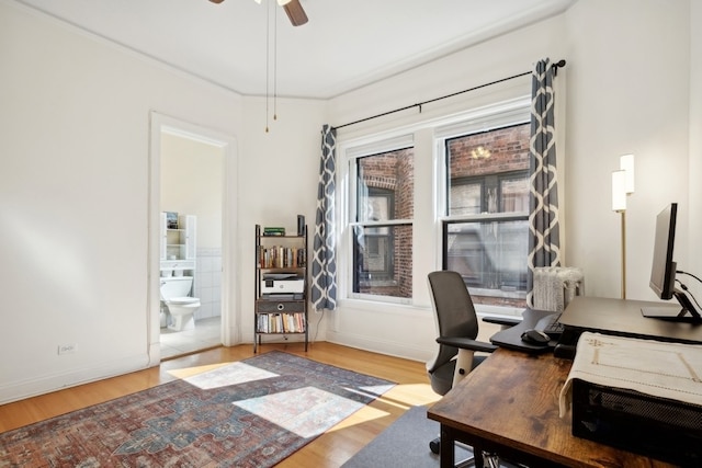 home office featuring ceiling fan, crown molding, and light wood-type flooring