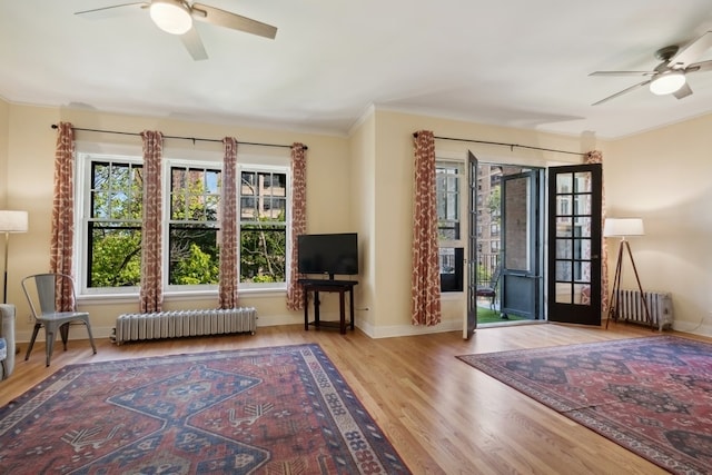 unfurnished room with ceiling fan, radiator, and light hardwood / wood-style flooring