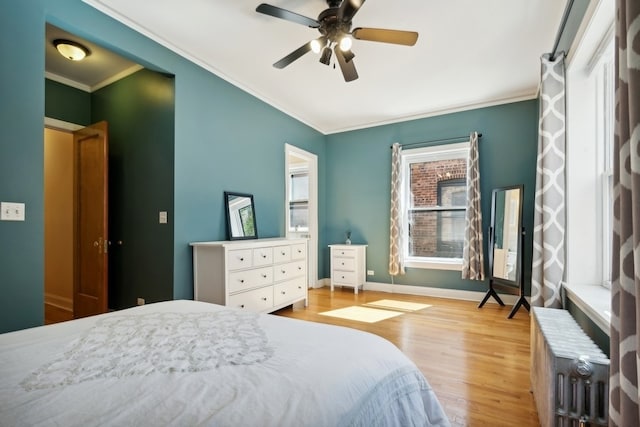 bedroom with ceiling fan, crown molding, and light hardwood / wood-style flooring