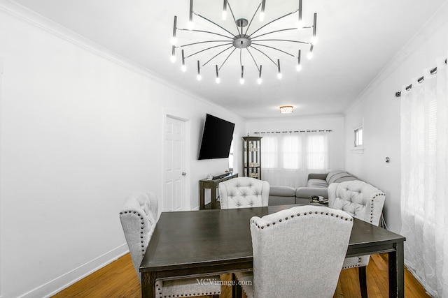 dining area featuring hardwood / wood-style floors, ornamental molding, and an inviting chandelier