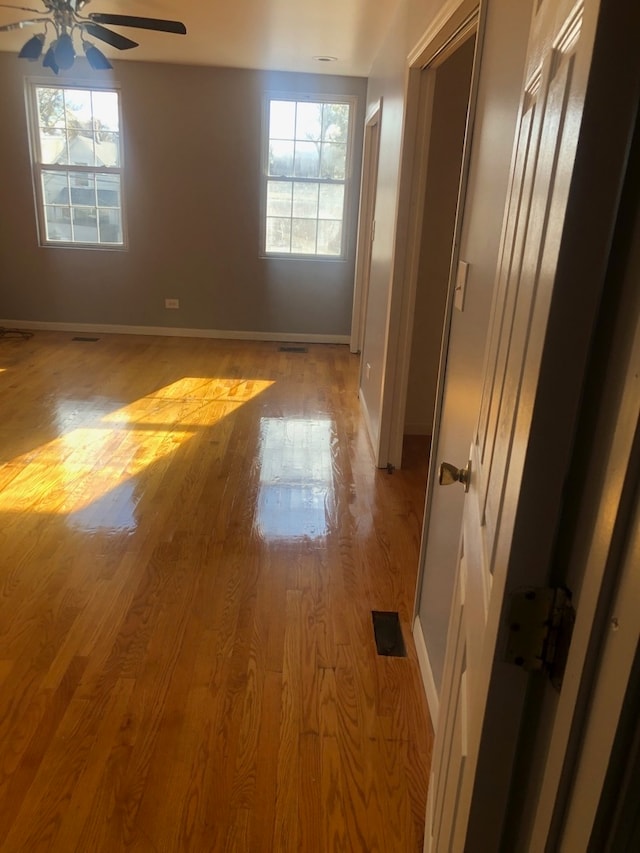 spare room featuring ceiling fan, plenty of natural light, and light wood-type flooring