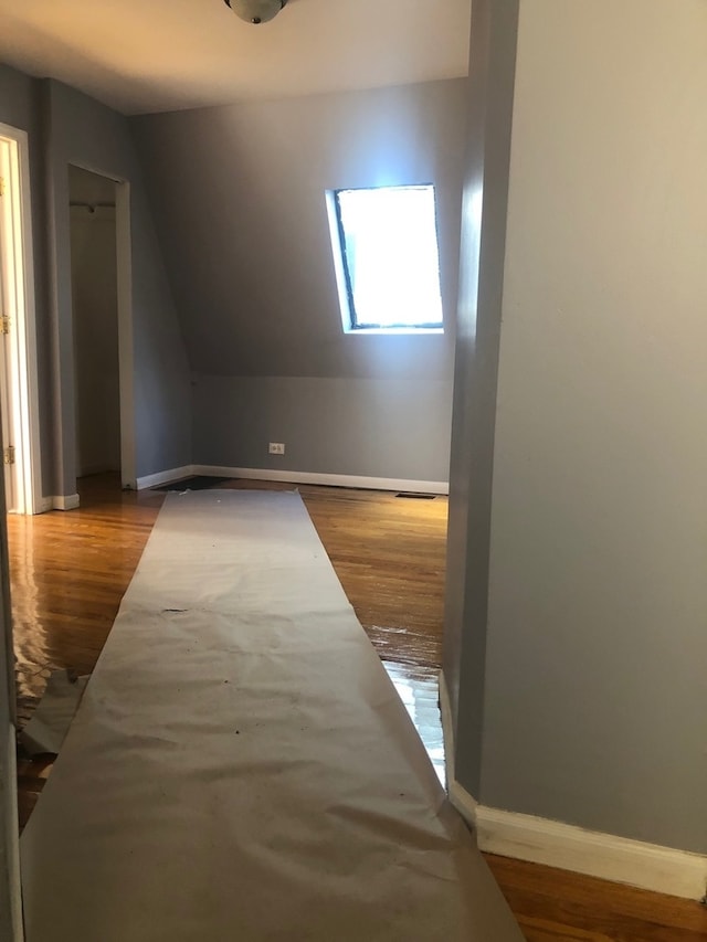 additional living space featuring light hardwood / wood-style floors and lofted ceiling