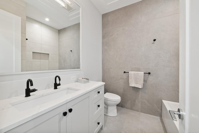 bathroom with a bathtub, vanity, tile walls, tile patterned flooring, and toilet