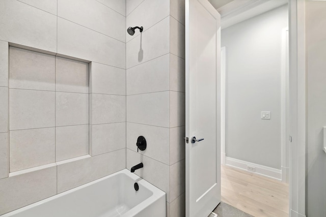 bathroom featuring hardwood / wood-style floors and tiled shower / bath