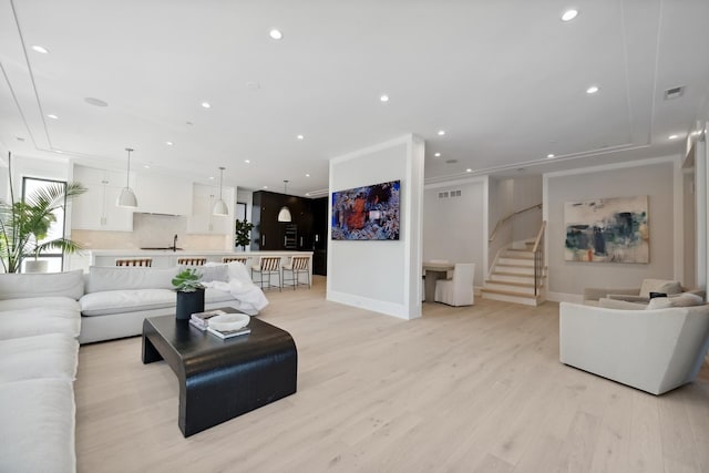 living room featuring light hardwood / wood-style floors and ornamental molding