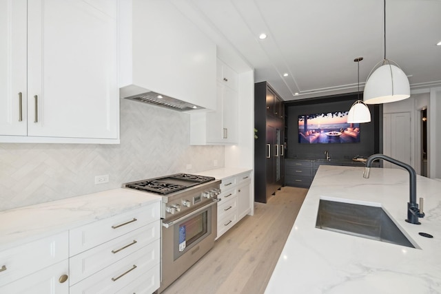 kitchen with light stone countertops, pendant lighting, high end stove, and white cabinets