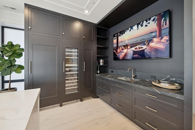 interior space featuring light stone counters, sink, and light hardwood / wood-style flooring