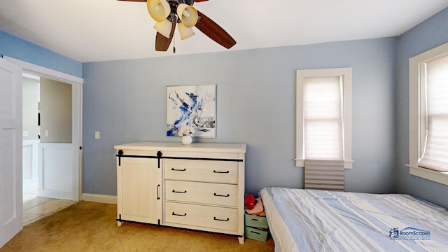 bedroom featuring light carpet, multiple windows, and ceiling fan