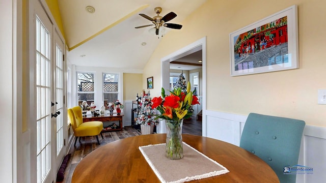 dining room featuring lofted ceiling, wainscoting, wood finished floors, and ceiling fan